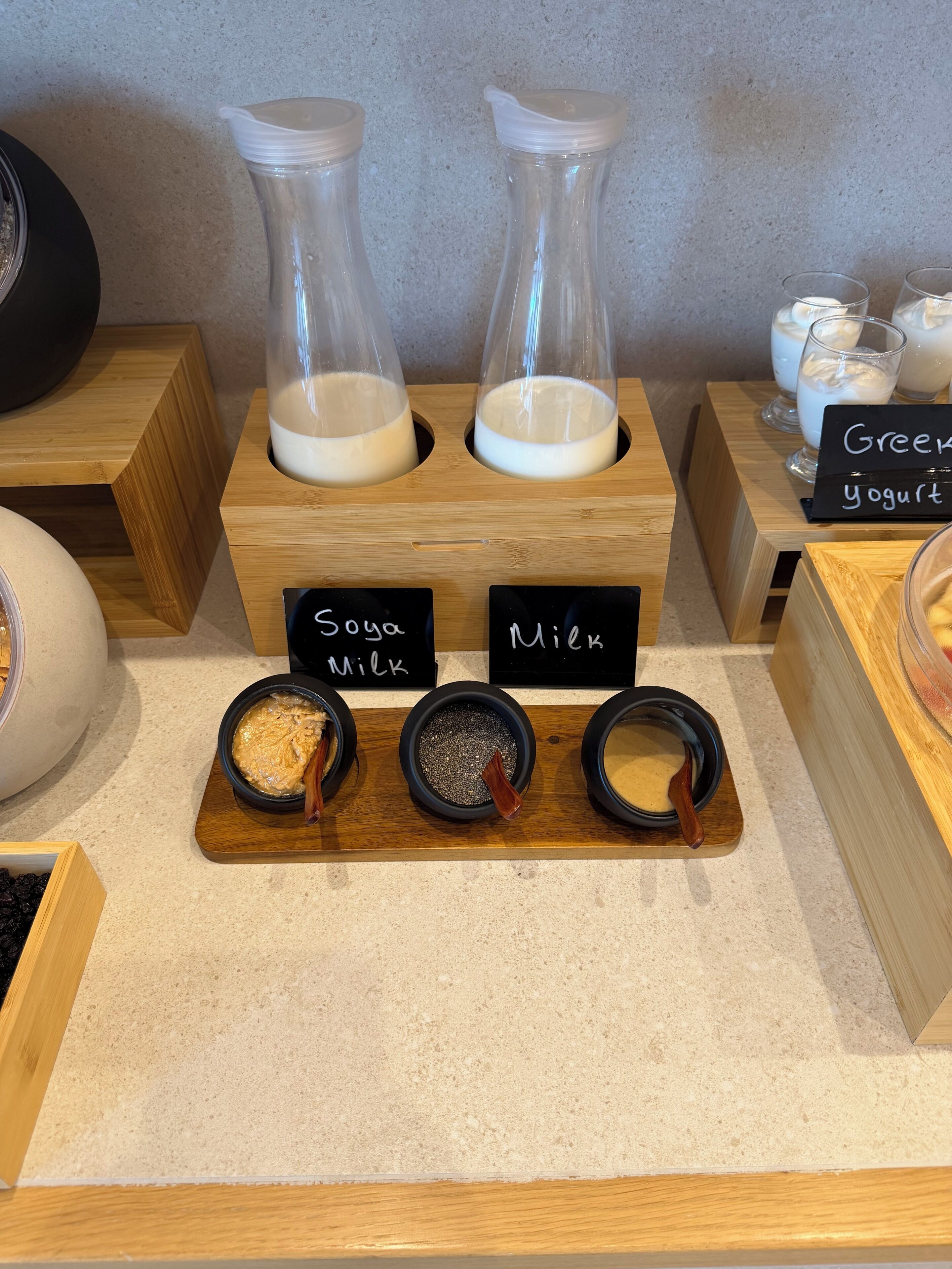 A display of dairy products with labels for Soya Milk and Milk, and a sign for Greek yogurt.