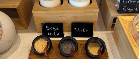A display of dairy products with labels for Soya Milk and Milk, and a sign for Greek yogurt.