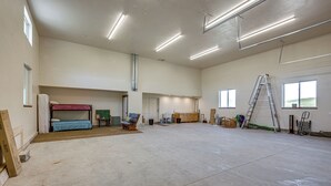 Tilava huone, jossa on kerrossänky, työpöytä ja tikkaat.