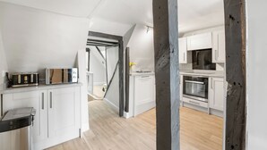 Een moderne keuken met witte kastjes, een magnetron en een broodrooster.