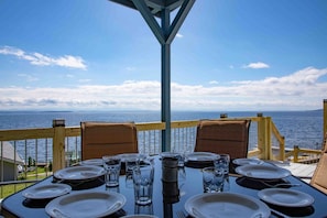 Mesa posta para refeição com vista para o mar.