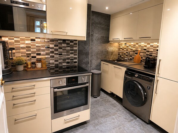A modern kitchen with a built-in oven, microwave, and dishwasher.