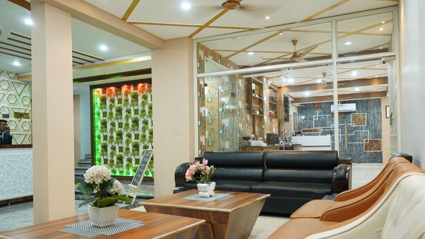 Eine moderne Lobby mit einer Rezeption, Ledersitzgelegenheiten und einer Wanddekoration mit Pflanzen.