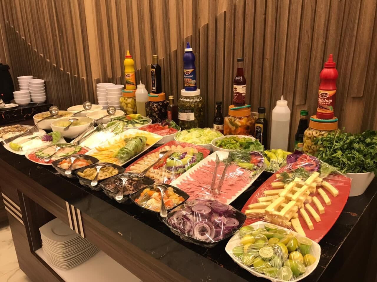 A buffet with various food items and condiments.