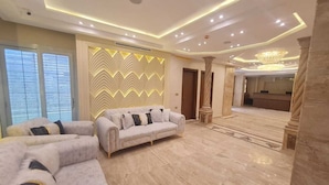 A spacious living area with a sofa set, a decorative wall, and a chandelier. - el masaadya hotel  (Cairo)
