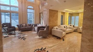A spacious living area with multiple sofas and armchairs arranged around a central coffee table. - el masaadya hotel  (Cairo)