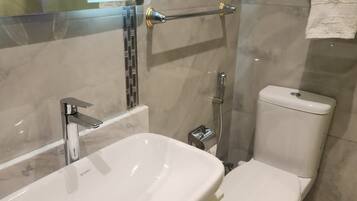 A bathroom with a white sink, a toilet, and a shower area.