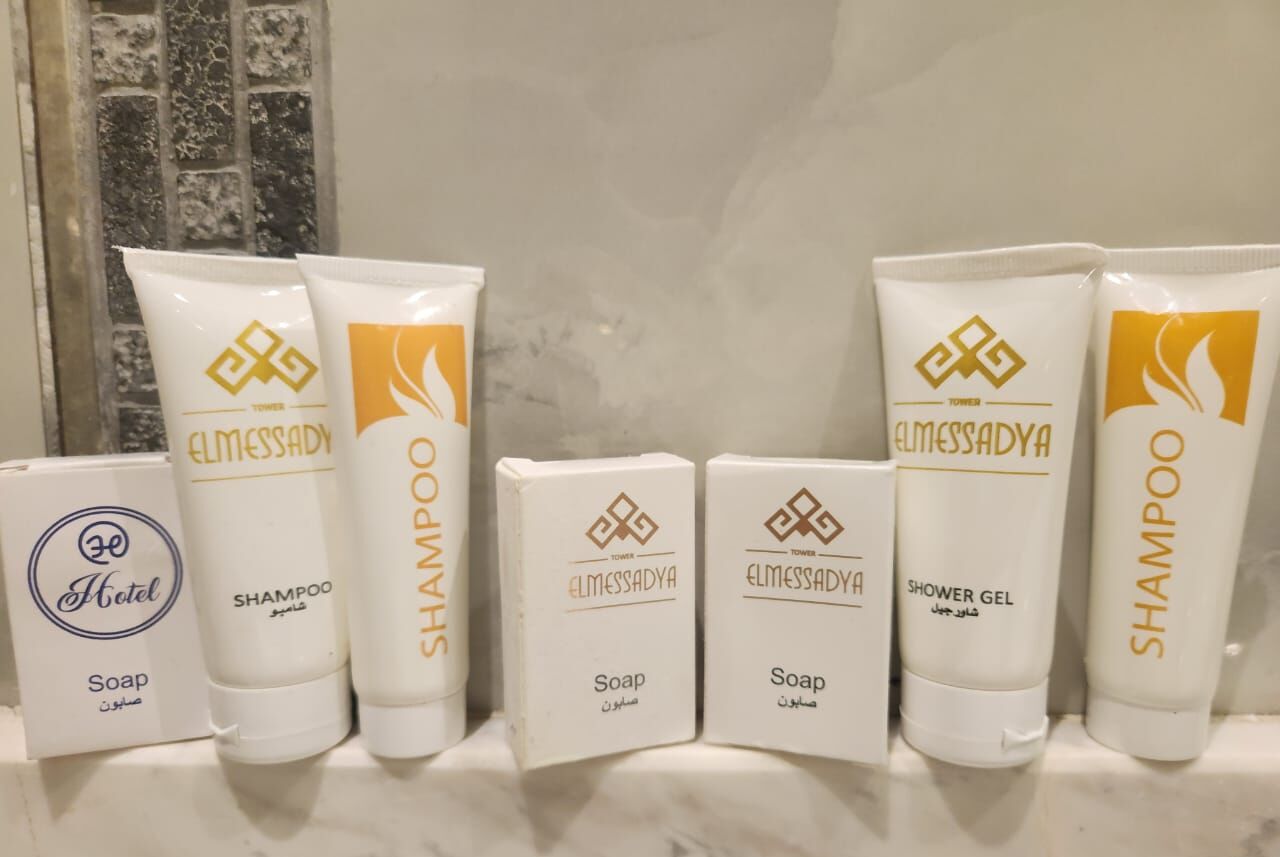 A variety of toiletries including shampoo, soap, and shower gel, arranged on a marble surface.