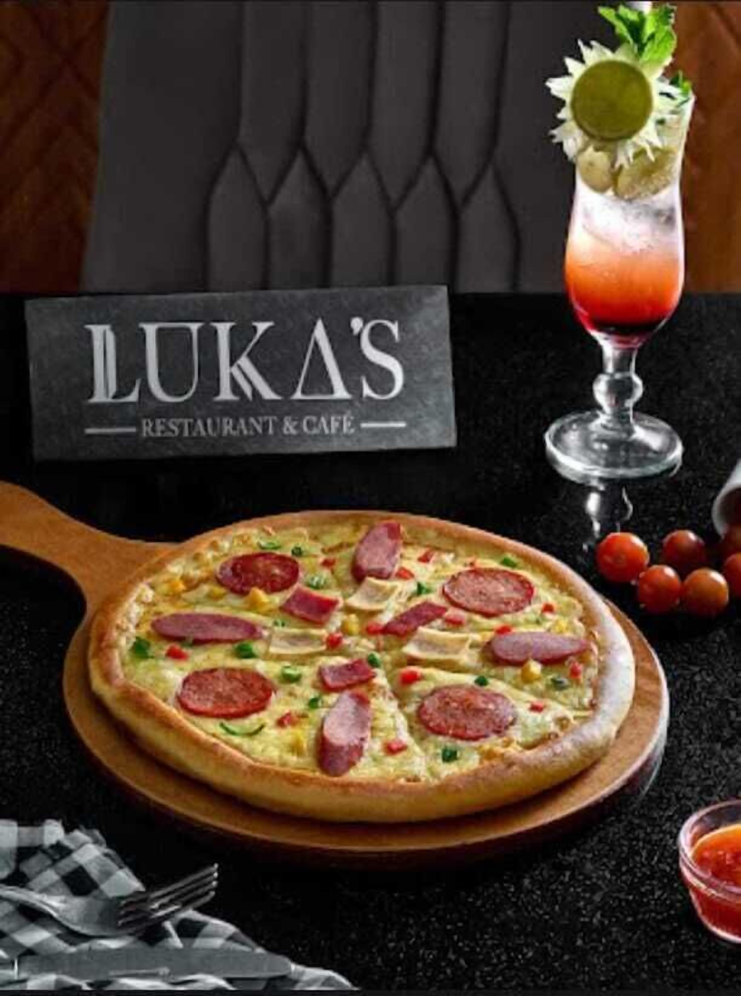 A pizza with pepperoni and cheese on a wooden board, a cocktail with a lemon garnish, and a sign that reads "LUKA'S RESTAURANT & CAFE".