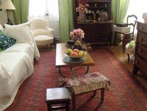 Relax in this inviting room with a comfortable sofa, dining table, and wooden dresser.