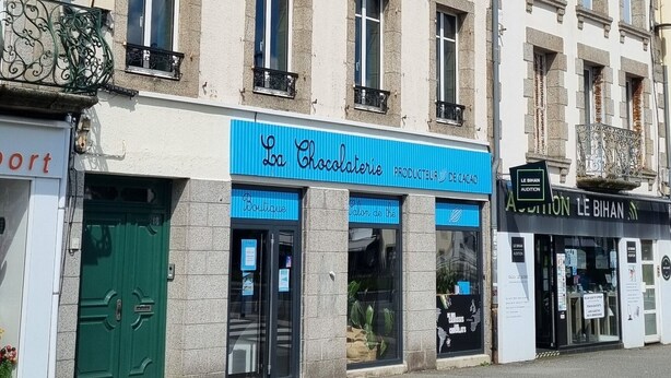 A street view with a building featuring a chocolate store and a bakery.