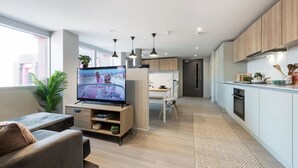 A modern apartment with a living room, dining area, and kitchen.