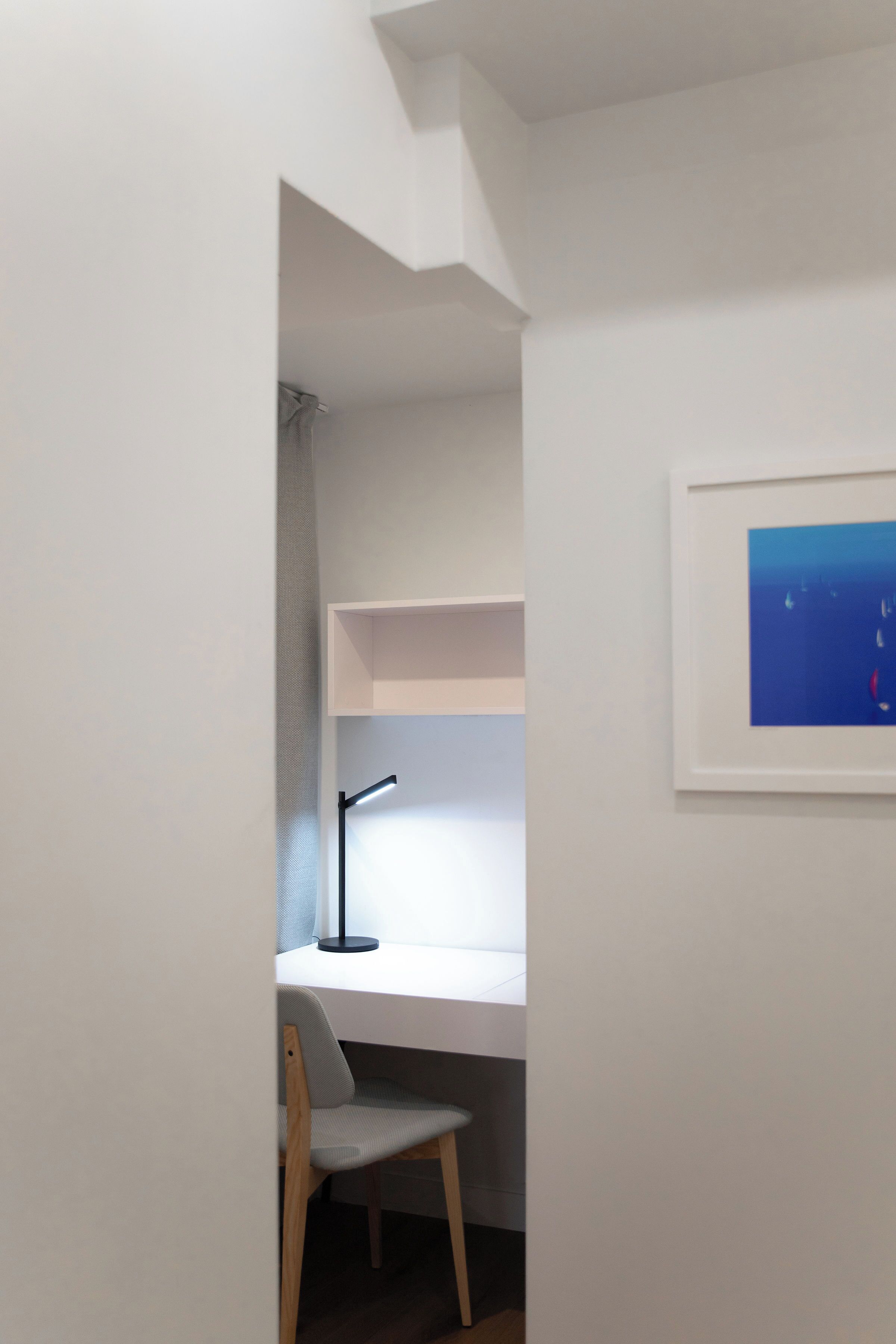 Un estudio con escritorio, silla y un cuadro en la pared.