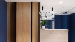 A reception area with a wooden panel design, a potted plant, and a sign reading "Hotel Leev Victoria." - Hotel Leev Victoire & Spa (Paris)