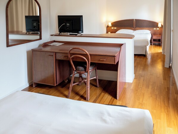 Habitación cuádruple, vista parcial al mar | Escritorio, tabla de planchar con plancha y wifi gratis 
