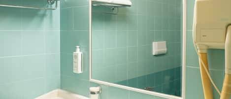 A bathroom with teal tiles, a white sink, a mirror, and a towel rack.
