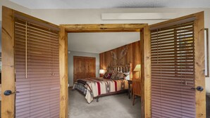 Una camera da letto con un letto, un comodino, una lampada e una testiera in legno.