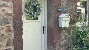 A stone cottage with a white door, a welcome mat, a nameplate reading "ANNIE'S COTTAGE", and a mailbox. - Annie's Cottage, Wellington
Stunning Cottage in lake District National Park (Seascale)