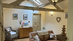 A cozy living room with a brown leather sofa, a wooden cabinet, and a wicker chair. There are framed pictures on the wall and a heart-shaped decoration. - Annie's Cottage, Wellington
Stunning Cottage in lake District National Park (Seascale)