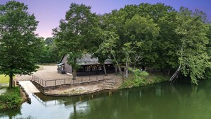 A riverside building with a covered deck and steps leading into the water.