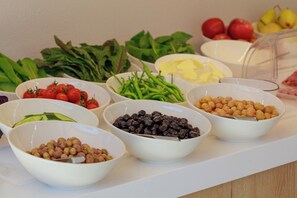A buffet table with various food items including tomatoes, cucumbers, green beans, olives, chickpeas, and other vegetables. - Casa Lumar Luxury Lodging - Adults Only (Fethiye)