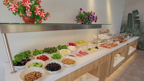 Un buffet garni de divers plats et une étagère en verre ornée de fleurs.