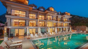 Un hôtel à plusieurs étages doté d’une grande piscine extérieure, de balcons et d’espaces de détente en plein air.
