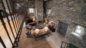 A spacious living area with a stone wall, a fireplace, and a chandelier. - Villa Los Magnolios "Paderne" (Paderne)