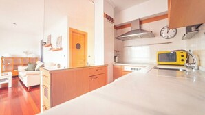 Une cuisine moderne avec des meubles en bois, un micro-ondes jaune et une cuisinière encastrée.