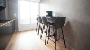 A modern kitchen with a dining area, including a table with chairs and a coffee machine.