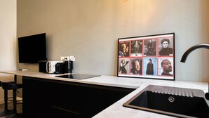 A modern kitchen with a built-in microwave, a coffee maker, and a sink. There is a framed collage of TIME magazine covers on the wall. - 15min to Duomo, Modern 1 Bedrm Flat A/C, 5G WiFi (Milan)