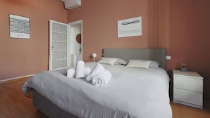 A neatly made bed with white linens and towels, a bedside table with a lamp, and a framed picture on the wall. - Genova25 - One Bedroom Apartment, Sleeps 3 (Milano)