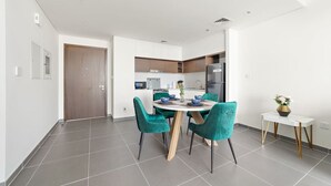 Una cocina moderna con armarios blancos, horno empotrado y refrigerador.