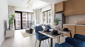 A modern living room with a dining area, a balcony, and a kitchen.