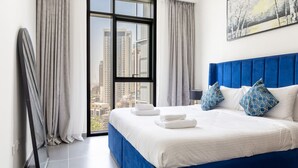 Una habitación de hotel con una cama grande, vistas a la ciudad y una ventana con cortinas.