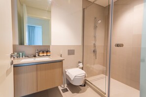 Une salle de bain moderne avec une douche à parois de verre, un meuble-lavabo en bois et un grand miroir.