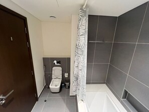 Ein Badezimmer mit Toilette, Dusche und Badewanne.