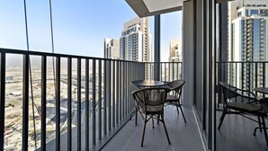 Un balcon donnant sur des immeubles de grande hauteur et un chantier de construction.