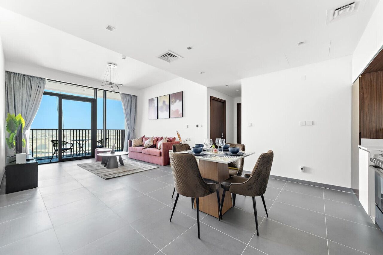 Una sala de estar moderna con comedor, ventanas amplias y vista al mar.