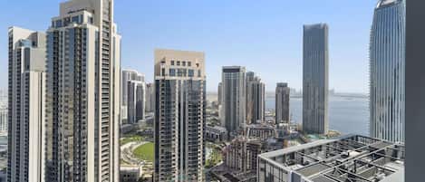 A high-rise building with multiple floors, a swimming pool, and a view of the sea.