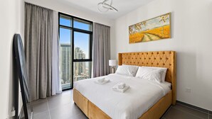 A hotel room with a large bed, a city view, and a painting on the wall. - HomesVIP | High-Class | Brand New (Dubai)