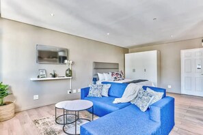 Relax in a spacious living room with a comfortable sofa, flat-screen TV, and stylish shelving unit.