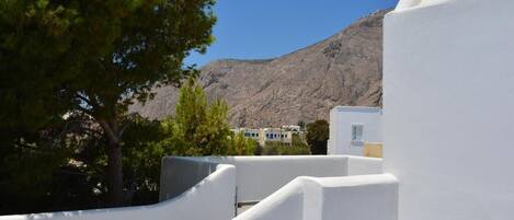 A white-walled building with a mountain in the background.