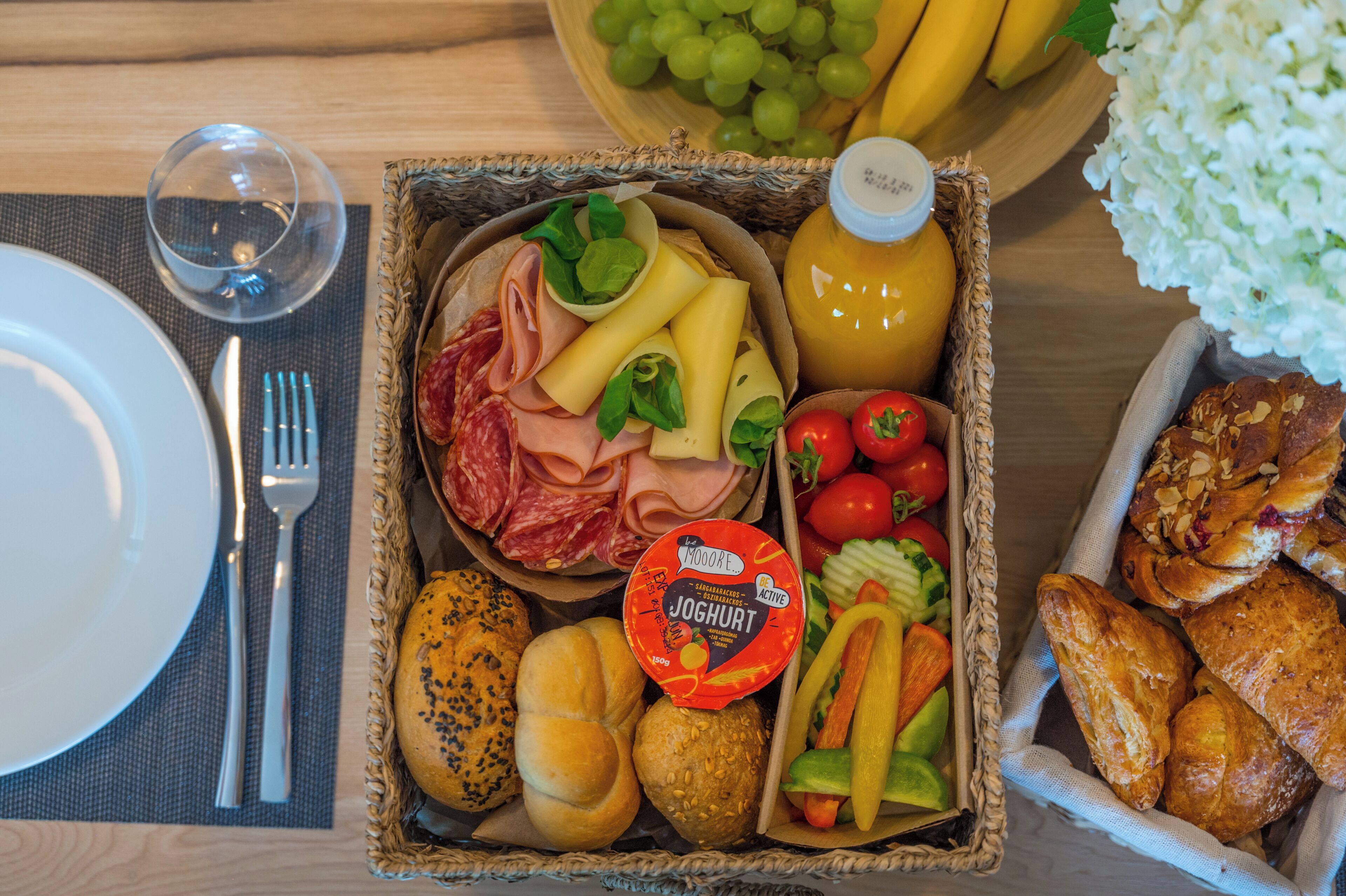 A breakfast buffet with various food items, a glass of juice, and a bottle of milk.