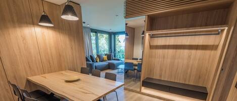 Un interior moderno con una mesa de comedor de madera, sillas y un banco empotrado.