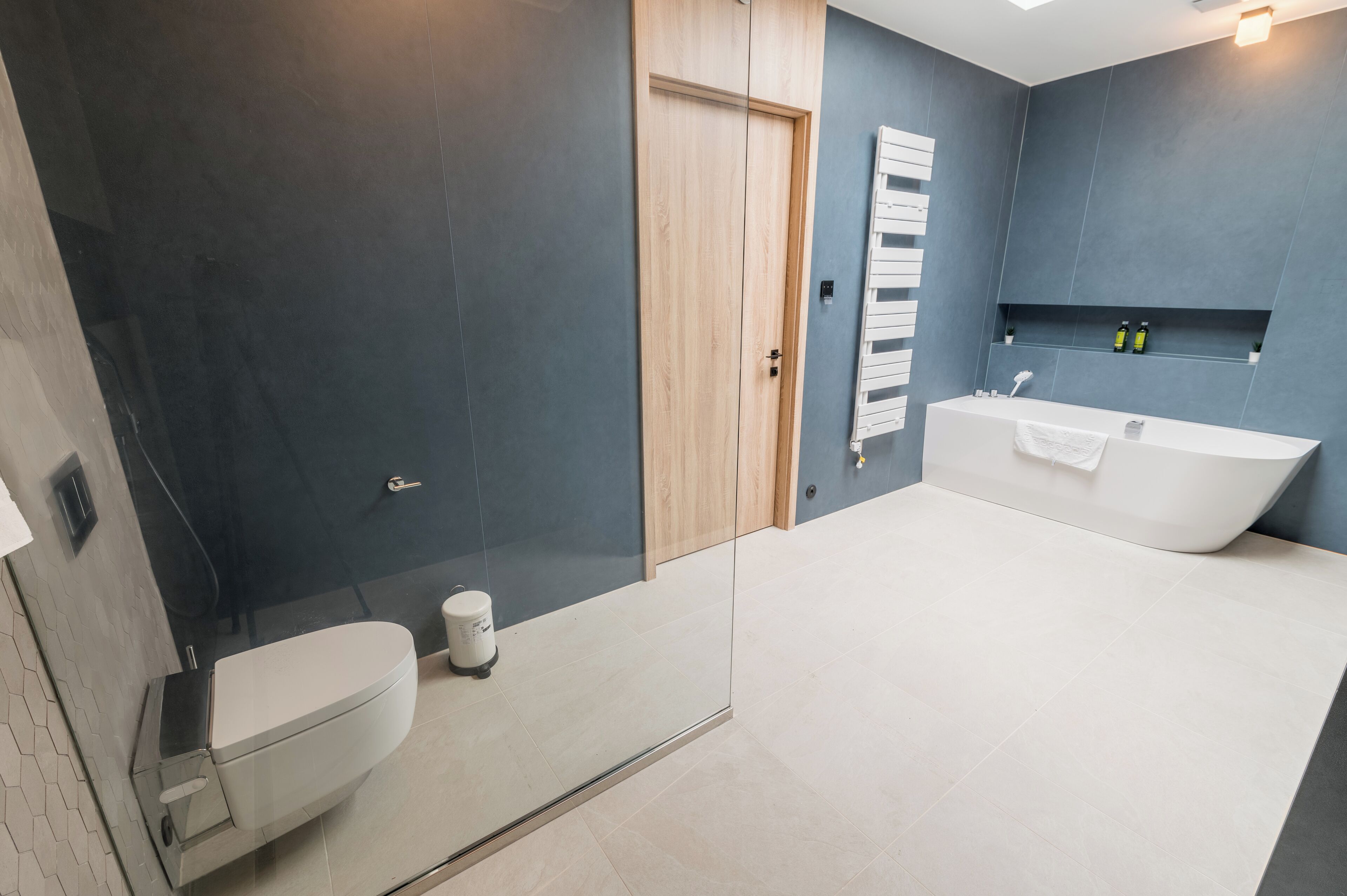 A modern bathroom with a toilet, shower, and bathtub.