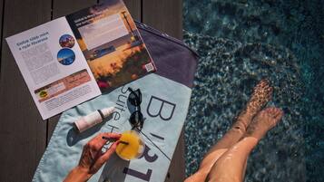 Un folleto sobre una toalla, con vista a la piscina.