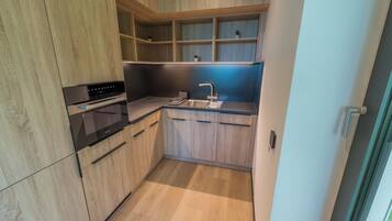 A modern kitchen with wooden cabinets, a built-in oven, and a sink.