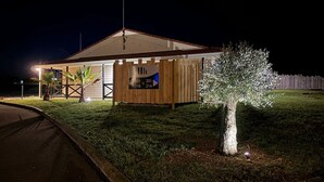 A small, single-story building with a sloped roof, a wooden fence, and a signboard with room numbers. - Halte Hotel (La Vergne)