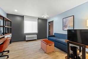 Una sala de estar moderna con un sofá, una mesa de centro, un televisor y una estantería.